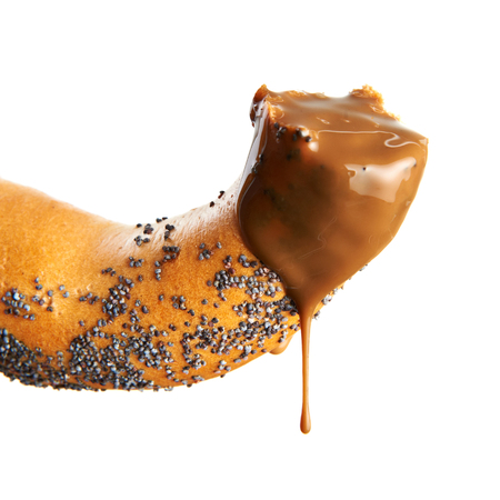 Bagel with poppy seeds and chocolate syrup isolated on whiteの写真素材