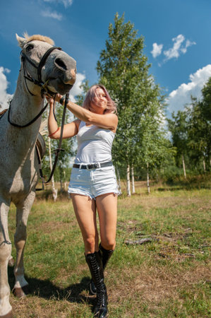 Beautiful young girl with a horse in fieldの写真素材