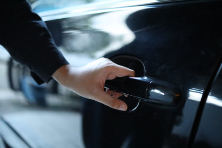 Closeup of the  driver hand while opening car's front door.