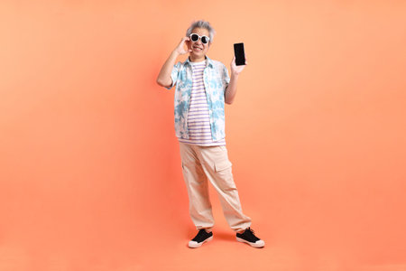 HAPPY SONGKRAN DAY. Asian tourist senior man in summer clothing with gesture of hand Holding mobile...
