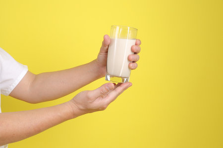 Hands holding Glass of soybean milk or soy milk. Chinese vegetarian festival Nine emperor god, J festival.の写真素材