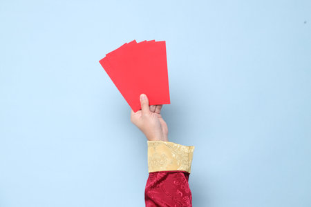 Happy Chinese new year. Hand of Asian Chinese  senior man wearing red traditional cheongsam qipao or...
