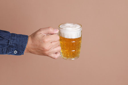 Asian manâs hand holding a beer mug, studio shotの写真素材