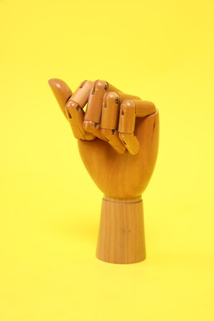 Hand of mannequin with multiple poses isolated on yellow background. Symbol, Puppet.の写真素材