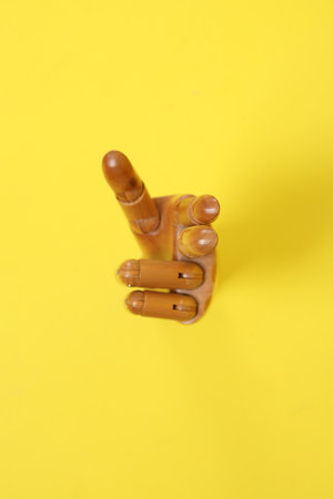 Hand of mannequin with multiple poses isolated on yellow background. Symbol, Puppet.の写真素材