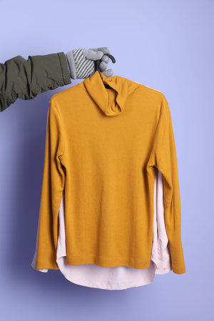 The Asian senior man wears winter clothes with gesture of hands holding clothes in hanger  isolated...