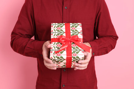 Merry Christmas, asian senior man in formal and casual red shirts with gesture of Holding gift box,...