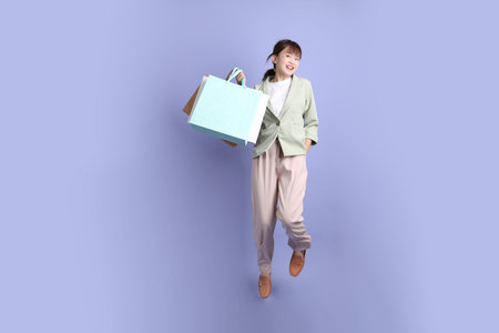 Young asian Businesswoman in formal outfit with gesture of holding shopping bag, Jumping isolated on...