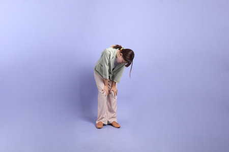 A young asian Businesswoman in formal outfit with gesture of exhausted, isolated on purple background.の写真素材