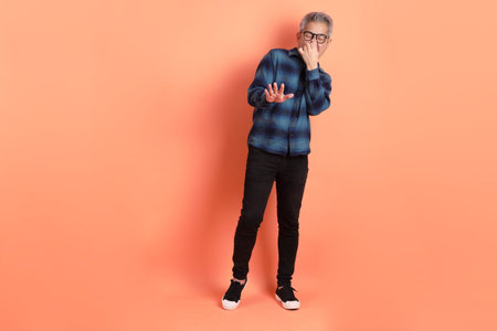Asian senior man in Green plaid casual clothes wearing glasses with gesture isolated on orange...