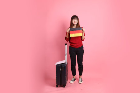 Asian college female student in red t-shirt or casual clothes carry school bag with gesture of holding flag isolated on pink background. Gen Zの写真素材