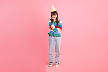 HAPPY BIRTHDAY, Asian woman with colorful rainbow winter clothes , casual look, birthday hat with gesture of thinking isolated on pink background. Gen Z,の写真素材