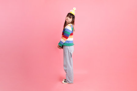 HAPPY BIRTHDAY, Asian woman with colorful rainbow winter clothes , casual look, birthday hat with gesture of Holding gift box isolated on pink background. Gen Zの写真素材