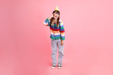 HAPPY BIRTHDAY, Asian woman with colorful rainbow winter clothes , casual look, birthday hat with gesture of Heart-shaped, mini heart, love isolated on pink background. Gen Z,の写真素材