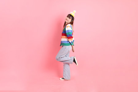 HAPPY BIRTHDAY, Asian woman with colorful rainbow winter clothes , casual look, birthday hat with gesture of Standing and smiling isolated on pink background. Gen Z,の写真素材