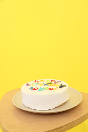Birthday Cake with  Happy Birthday text isolated on yellow background, Happy Birthday Concept. Family, Party hat , Gift boxの写真素材