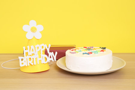 Birthday Cake with  Happy Birthday text, Party hat , Gift box  isolated on yellow background, Happy Birthday Concept. Familyの写真素材