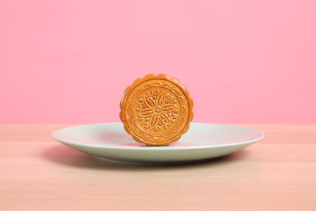 Traditional Chinese dessert Moon cake or Chinese pastry isolated on pink background. Chinese traditional Mid-Autumn Festival, Moon Festival.の写真素材