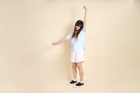 Young Asian woman wearing a light blue polo shirt, and white shorts, exhausted, Laziness and unserious
 against a plain beige background. College student, Gen Z, Summerの写真素材