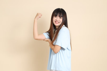 Young Asian woman wearing a light blue polo shirt, and white shorts, healthy, strong against a plain beige background. College student, Gen Z, Summerの写真素材