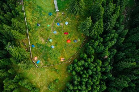 Camping site with tents seen from a drone in the dense woods.の写真素材