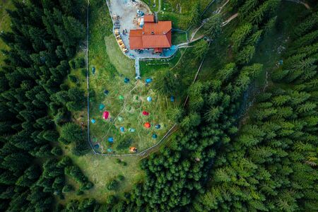 Camping site with tents seen from a drone in the dense woods.の写真素材