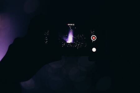 Stage lights and crowd of audience with hands raised at a music festival. Fans enjoying the party vibes.の写真素材