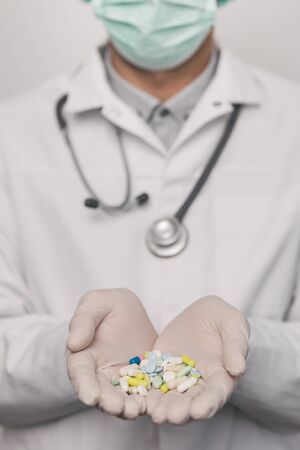 Close-up of male doctor giving too much pills.  Overdose concept.の写真素材