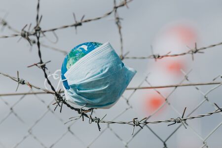 Surgical mask on Earth globe. Epidemics concept. World infected with Covid-19 / Coronavirus.の写真素材