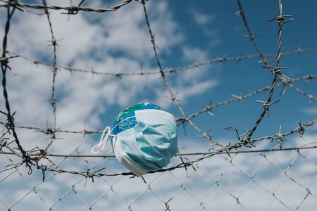 Surgical mask on Earth globe. Epidemics concept. World infected with Covid-19 / Coronavirus.の写真素材