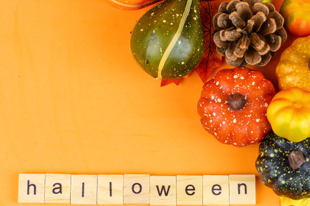Halloween background with pumpkins and wooden letters on orange background.の写真素材