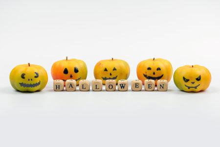 Halloween concept with pumpkins and wooden cubes on white background.の写真素材