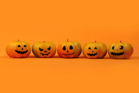 Halloween pumpkins with faces on orange background. Halloween concept.の写真素材