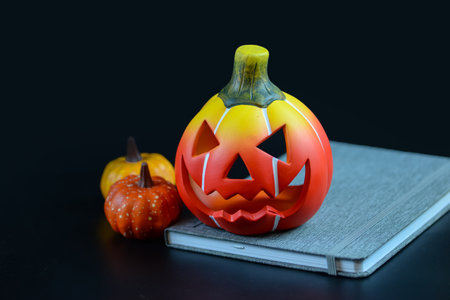 Halloween pumpkin and book on black background, Halloween holiday concept.の写真素材