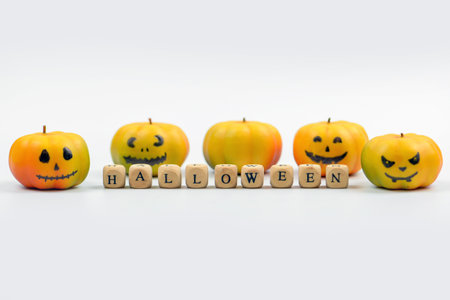 Halloween concept. Halloween pumpkin and wooden cubes with letters on white backgroundの写真素材
