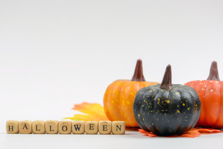 Halloween decoration with pumpkins and fall leaves on a white backgroundの写真素材