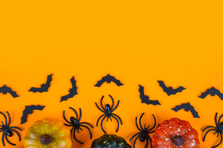 Halloween background with spiders, pumpkins and bats on orange backgroundの写真素材