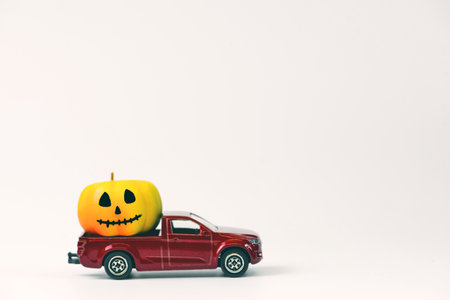 Halloween pumpkins on red toy car isolated on white background.の写真素材