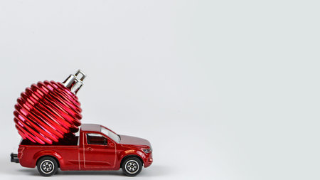 Red toy car with christmas ornaments on a white backgroundの写真素材