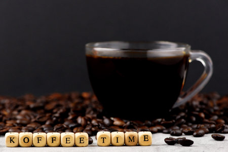 Coffee beans with cubes and cup of coffee on black backgroundの写真素材