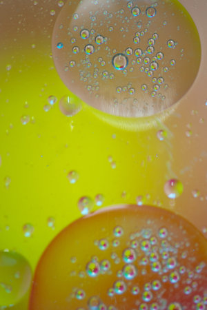 bright oily drops in water with colorful background, very shallow dofの写真素材