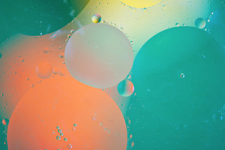 bright oily drops in water with colorful background, close-up shot
