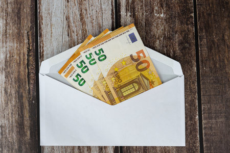Envelope with euro banknotes on wooden background, top viewの写真素材