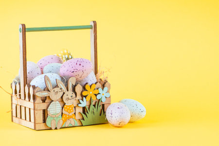 Colored Easter Eggs in Basket on Yellow Background, Happy Easter. High quality photo