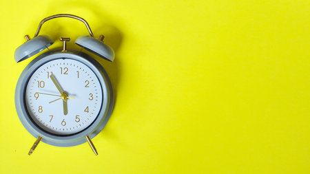 Alarm clock on a yellow background, concept of work and trainingの写真素材