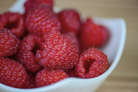 Fresh raspberries in a white plate close-up