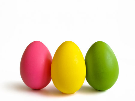 Three vibrant and distinctively colored eggs are currently arranged in a neat row, showcasing their beautiful hues and varietyの写真素材