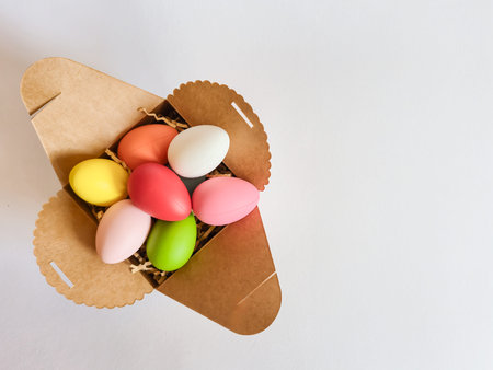 A delightful box filled with an assortment of colorful and vibrant Easter eggs set against a clean...