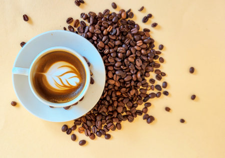 A warming cup of rich espresso sits elegantly among fragrant coffee beans, beautifully showcasing latte artの写真素材