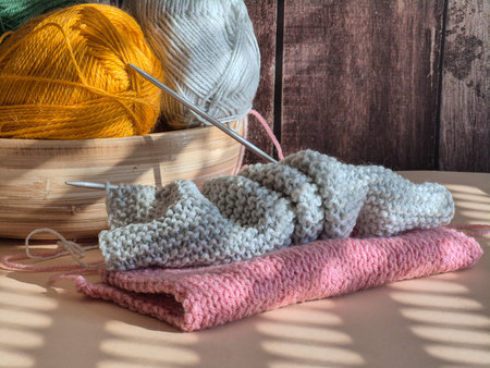 A peaceful and serene knitting scene that features vibrant yarn and needles perfectly arranged on a...